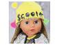 Poupée avec bonnet jaune 'Scooter' et veste scintillante.
