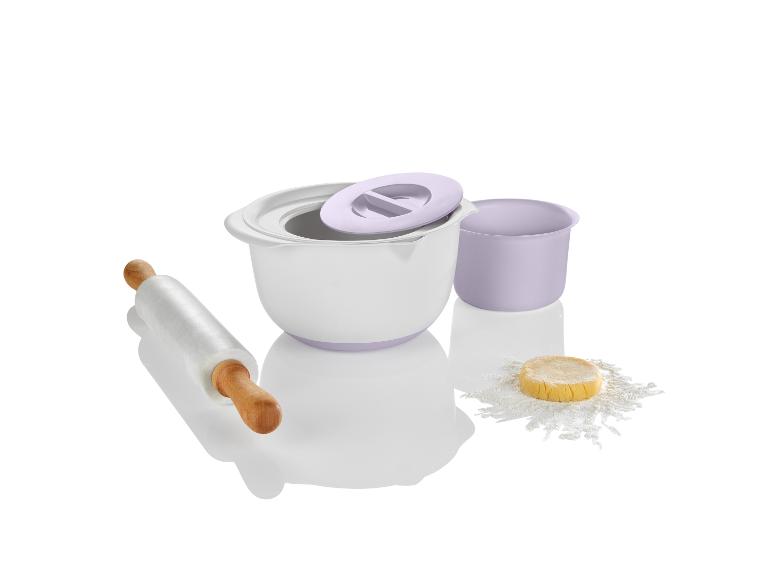 Un bol blanc, un rouleau à pâtisserie et un petit bol avec de la farine et de la pâte.