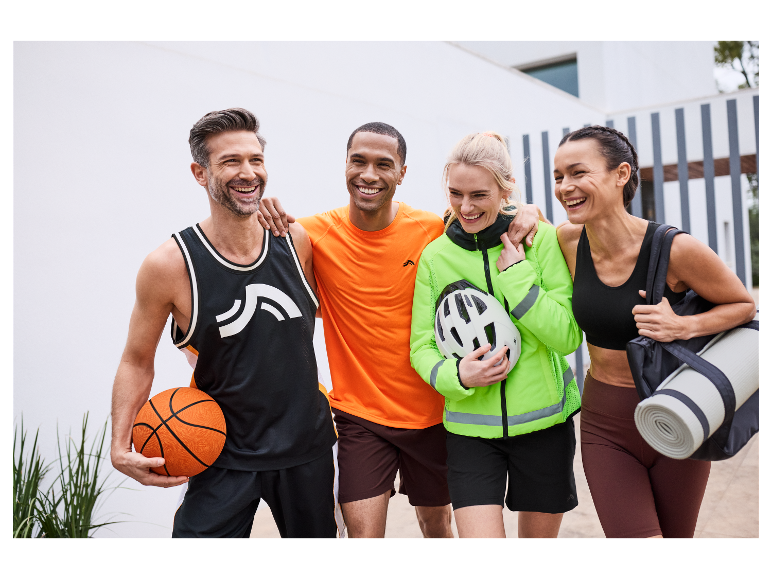 Quatre amis souriants portent des vêtements et des articles de sport.