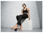 Une femme en leggings noirs et soutien-gorge de sport masse son pied avec une balle de massage.