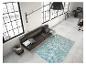 Un intérieur moderne avec un canapé en cuir marron foncé, un tapis turquoise et un lampadaire noir.