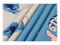 Tissu avec imprimé de personnage de dessin animé bleu et beige, avec des plis.