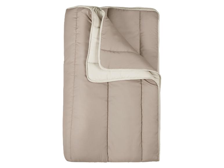 Sac de couchage beige avec intérieur clair, plié en deux