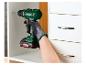 Une personne utilise une perceuse-visseuse Parkside X20V Team pour percer un trou dans un placard.