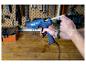 Homme chargeant un pistolet à colle bleu LIVARNO® Klebepistole »EG340« avec un bâton de colle dans un atelier.