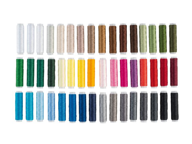 Un grand assortiment de fils à coudre colorés disposés en rangées par couleur.