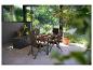 Ensemble de salle à manger de jardin avec chaises et table marron sur une terrasse avec coffre de rangement.