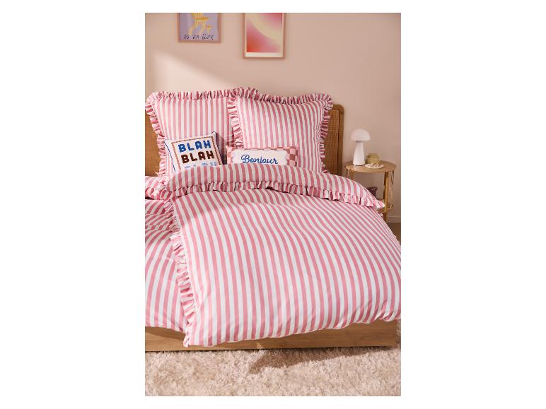 Parure de lit rayée rose et blanc avec volants, un oreiller 'BLAH BLAH' et un oreiller 'Bonjour'.