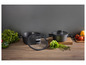 Deux casseroles noires avec des couvercles en verre sur un comptoir en bois.