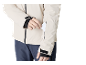 Homme en veste claire et pantalon bleu foncé mettant une carte dans la poche de sa manche.
