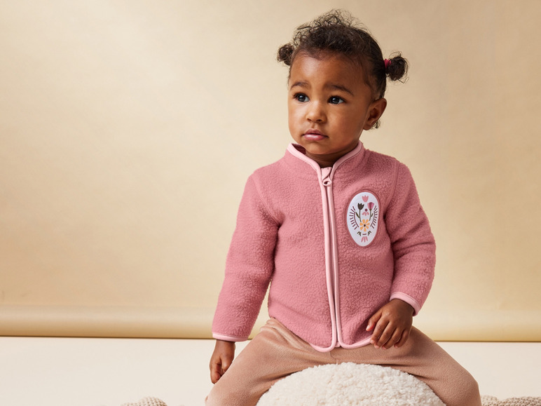 Une combinaison en polaire rose pour bébé avec un motif floral.