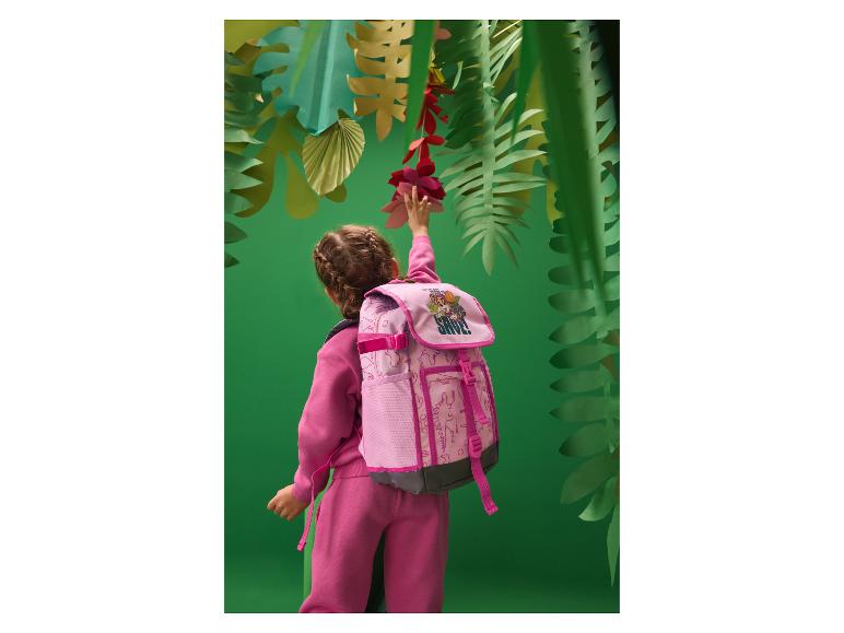 Fille en survêtement rose et sac à dos atteignant des fleurs en papier dans un décor de jungle.