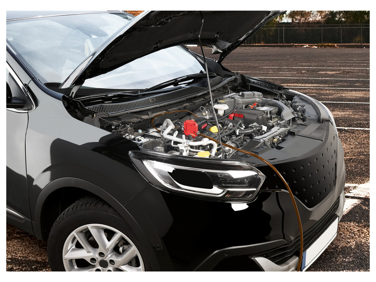 Une voiture noire avec le capot ouvert, montrant le moteur et un produit LUKAS.