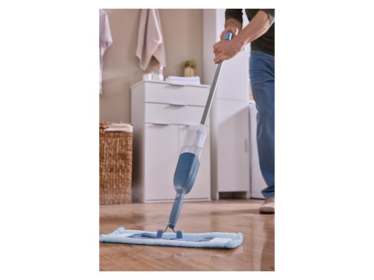 Homme nettoyant un sol en bois avec une serpillière pulvérisatrice bleue.