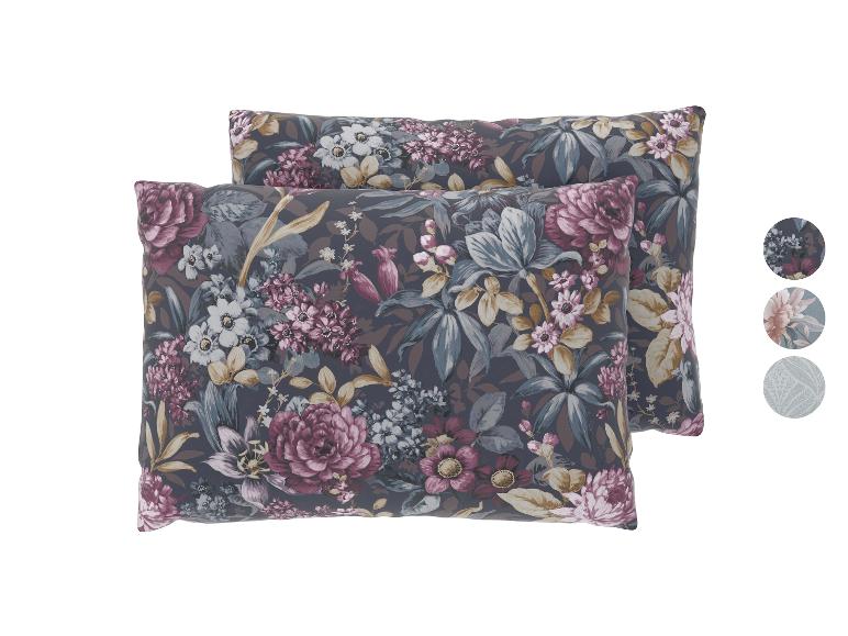Deux oreillers à motif floral sombre avec des fleurs roses, blanches et bleues.