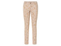 Pantalon beige avec un motif de feuilles blanches.
