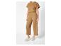 Combinaison pantalon et top coordonnés couleur camel, et baskets blanches.