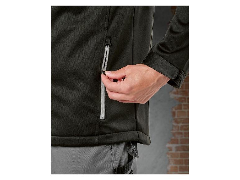 Gros plan d'une personne fermant une veste noire avec une fermeture éclair.