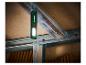 Une lampe de travail Parkside verte suspendue à une poutre en bois.