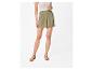 Shorts vert olive taille haute avec sandales minimalistes.