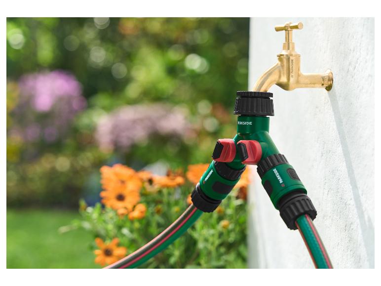 Répartiteur de tuyau d'arrosage PARKSIDE connecté à un robinet dans le jardin.