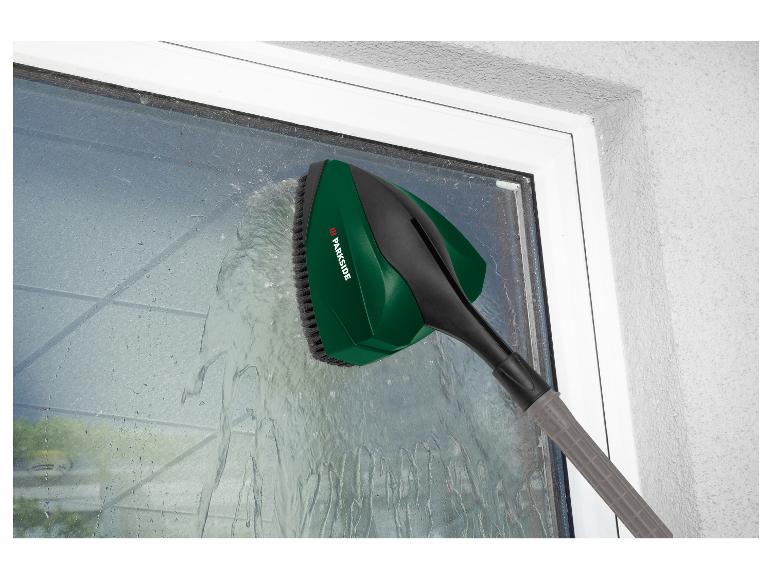 Un nettoyeur de fenêtres Parkside vert avec une brosse nettoie une fenêtre.