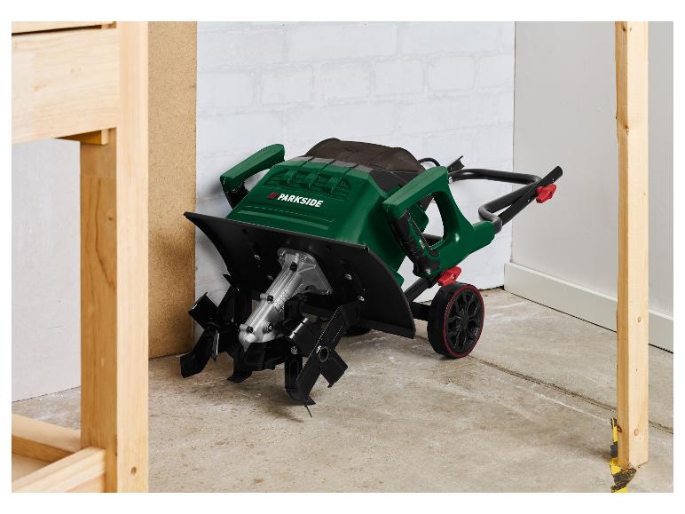 Motoculteur électrique Parkside vert avec roues, sur un sol en béton.