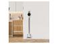 Aspirateur sans fil dans une cuisine moderne avec parquet et armoires blanches.