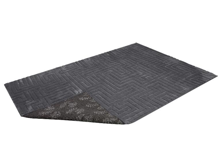 Tapis de bain gris avec motif géométrique et dessous antidérapant à motif floral.