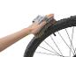 Nettoyage d'une roue de vélo avec une brosse.