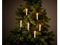 Sapin de Noël avec bougies allumées, créant une ambiance chaleureuse et festive.