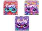 Trois boîtes de jouets en peluche Furby en différentes couleurs.