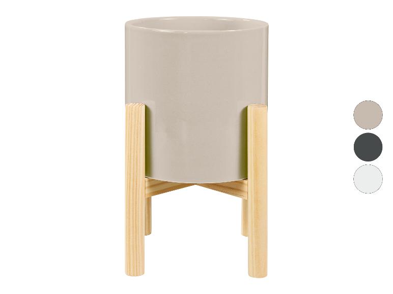 Pot de fleurs gris avec un support en bois.