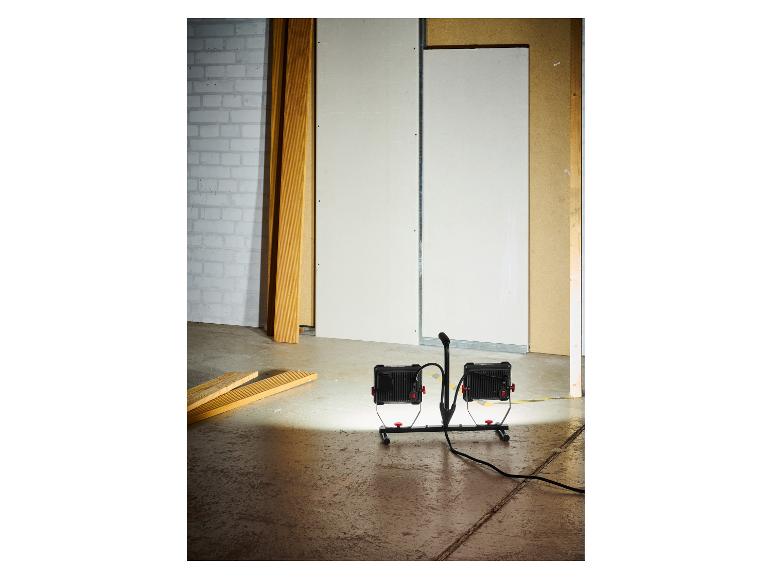 Deux projecteurs LED portables éclairent un chantier.