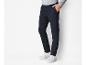 Un homme portant un pantalon bleu marine et des baskets blanches.