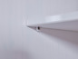 Une étagère blanche fixée au mur avec une vis.