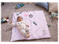 Un bébé est allongé sur un tapis rose avec des nombres et des jouets.