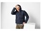 Homme en doudoune bleu marine et bonnet beige clair.