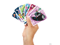 Main tenant un éventail de cartes à jouer colorées avec des personnages animés et des chiffres.
