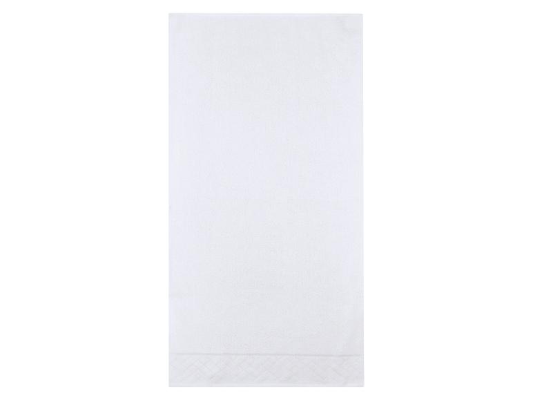 Serviette blanche avec un motif subtil en bas.