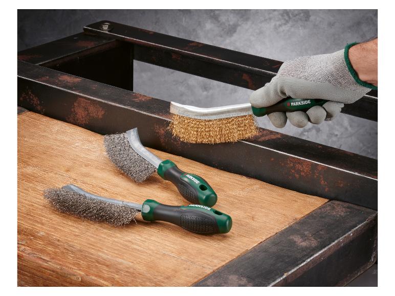 Brosses métalliques PARKSIDE nettoyant la rouille d'un cadre métallique sur une surface en bois.