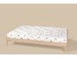 Drap-housse blanc à motifs de nœuds rouges sur un lit en bois.
