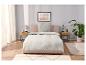 Parure de lit et linge de maison beige clair dans une chambre moderne.