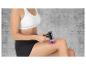 Une femme utilise un pistolet de massage sur sa jambe.