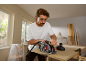 Homme coupant une planche de bois avec une scie circulaire sans fil, portant lunettes et bouchons d'oreille.