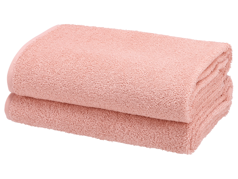 Deux serviettes de bain roses douces et moelleuses.