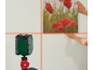 Niveau laser projetant des lignes sur un mur où un tableau est accroché.