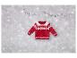 Un pull rouge en tricot avec un motif de Noël et des étoiles argentées