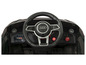 Le tableau de bord d'une voiture jouet avec un volant Audi, un lecteur MP3 et un port USB.