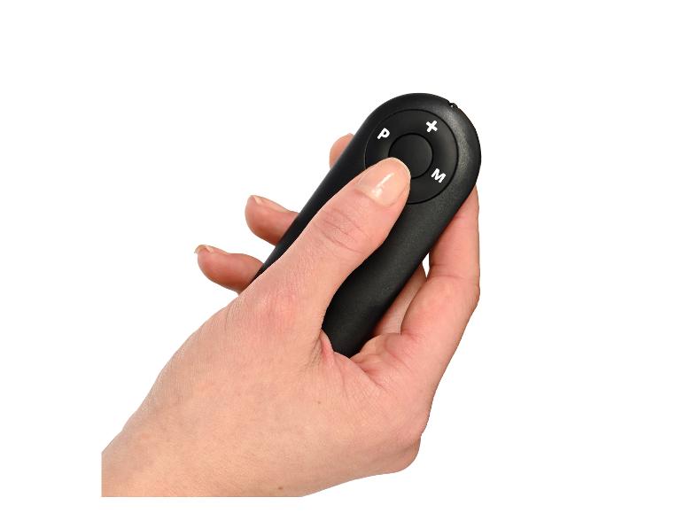 Main tenant une télécommande noire avec des boutons P, +, M